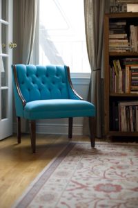 Размещенное кресло у окна бирюзового цвета